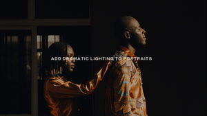 Two people in gold clothing lit from the side against a dark interior