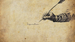 Vintage illustration of a hand holding a quill above the word Inspiration