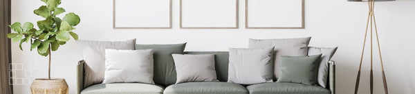 Above sofa wall art display with pale frames and sage cushions