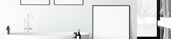 Bathroom wall art frames beside a white bathtub and tall window
