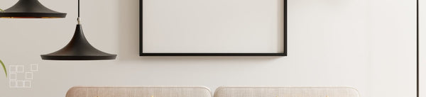 Traditional wall art frame above a pale sofa beside dark pendant lights