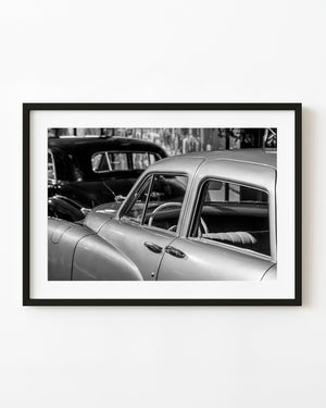 1940s Cadillac sedan with open windows and white steering wheel in black and white