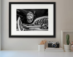 Curved Buick bumper reflecting light beneath the headlight and grille