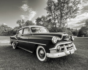 Three-quarter view of a dark Chevrolet Bel Air with whitewall tyres on grass