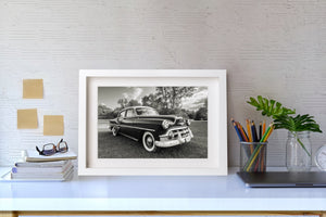 Dark Bel Air bodywork and whitewall tyres beside a tree-lined lawn