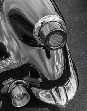 Circular Corvette tail light projecting from reflective bodywork above the rear bumper
