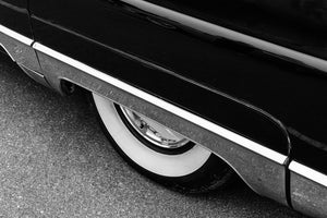 Whitewall wheel partly hidden beneath dark Lincoln Capri bodywork and chrome trim
