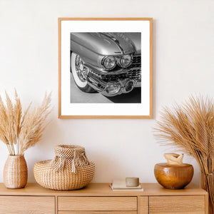 Long Cadillac hood line above bright twin headlights and curved metal trim