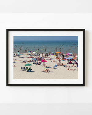 Busy summer shoreline at Wasaga Beach, Ontario, with colourful umbrellas and swimmers.