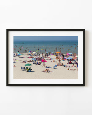 Busy summer shoreline at Wasaga Beach, Ontario, with colourful umbrellas and swimmers.