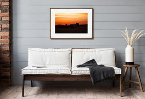 Farmhouse and windmill silhouettes under a bright rural sunrise.