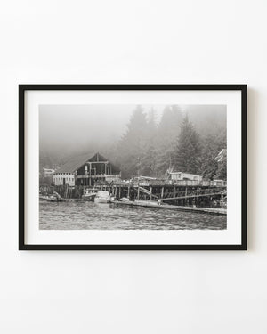 Abandoned British Columbia waterfront resort with weathered docks beneath a misty forest.