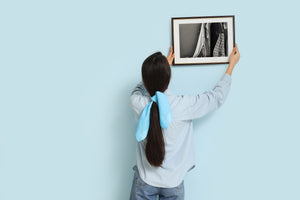 Layered shirts and sleeves hang against a worn wall in an abandoned house.