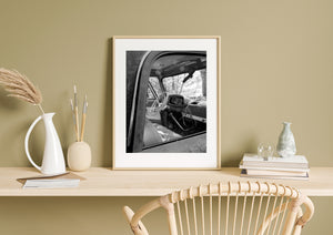Abandoned Dodge cab slowly overtaken by woodland, photographed in black and white.
