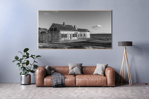 Weathered Maine house with bare branches and shoreline scenery in monochrome