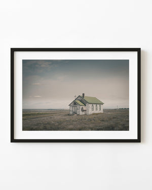 Abandoned wooden church on the Manitoba prairie with a green roof and a cross