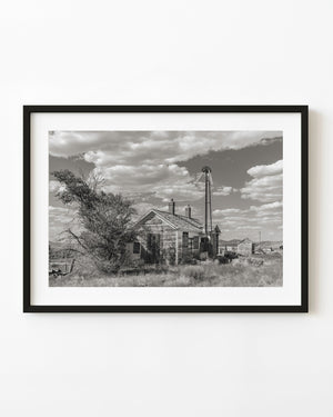 Abandoned railway station in Currie, Nevada, beneath dramatic clouds in black and white
