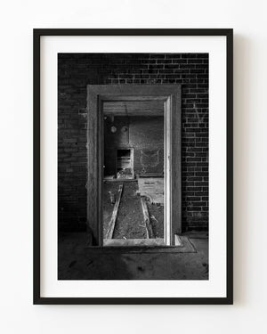 Empty wooden doorways inside an abandoned brick building in Portland, Maine, black and white