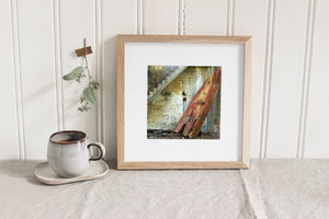Square colour photograph of a forgotten rowboat in a derelict industrial building