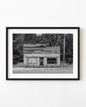 Abandoned rural American brick store with broken upper boards in black and white