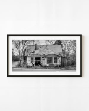Abandoned rural New York house with barred windows and a lawn chair, black and white