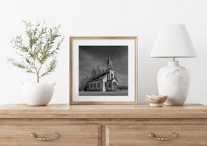 Black and white photograph of pointed church windows and worn wooden boards