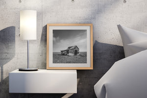 Weathered wooden walls contrast with an uninterrupted flat prairie horizon