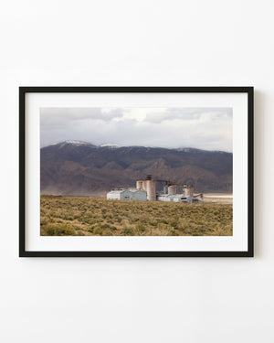 Abandoned soda ash plant beneath broad California mountain slopes.