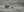 Panoramic monochrome landscape of weathered homes across an open grassy desert.
