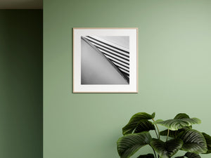 Pale metal strips and deep shadows form diagonal bands on a vintage car hood.