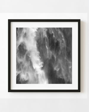 Close-up of falling water and fine spray at a New Zealand waterfall in black and white.
