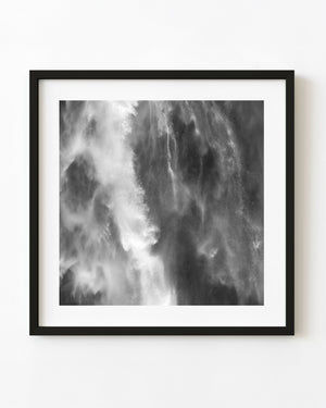 Close-up of falling water and fine spray at a New Zealand waterfall in black and white.