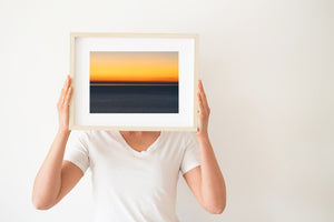 Golden yellow sky and deep blue sea form broad bands in a minimalist dusk photograph.