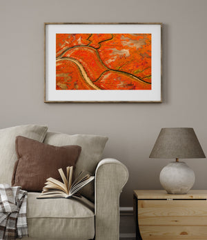 Smaller channels branch across warm autumn colours above a broad curved waterway.