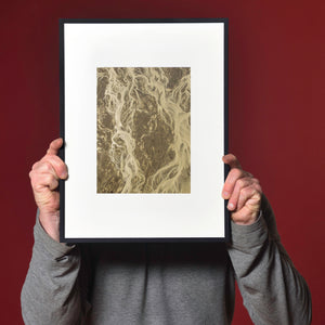 Sand-coloured waterways form an abstract pattern over brown tidal flats.