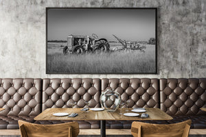 Wide Alberta prairie photograph of a tractor and seeder against a distant horizon.