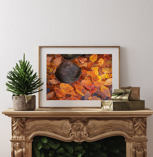 Horizontal autumn photograph of colourful leaves gathered beside dark stream stones.