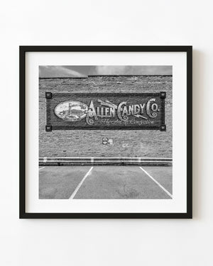 Allen Candy Company mural and empty parking bays in Pontiac, Illinois, photographed in black and white.