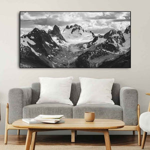 Dark foreground slopes lead toward bright ice and distant broken peaks.
