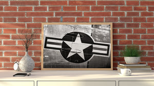 Black and white aircraft detail contrasts geometric insignia with worn rivets and surface marks.