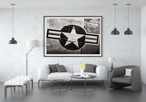 A dark circular emblem and pale star stand out against curved metal panels and fine fasteners.
