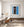 White doorway trim separates a dark flag-filled interior from the bold blue exterior.