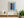 Flag folds and shadowed furnishings appear within a tall narrow opening in a blue wall.