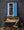 Red, white and blue repeat in the flag and doorway around a small back-room scene.