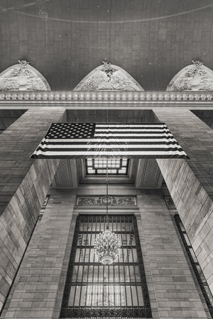 Stars and stripes stretch across Grand Central’s stone interior above a dark window grid.