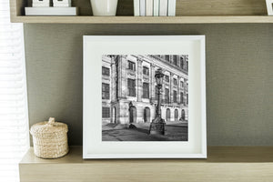 Ornate lamp base and repeated palace windows in early Amsterdam light.