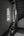 Light from tall arched windows meeting a dark timber staircase in an Amsterdam building.