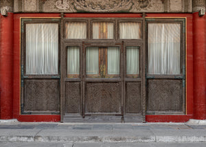 Symmetrical Chinese doors framed by red palace walls