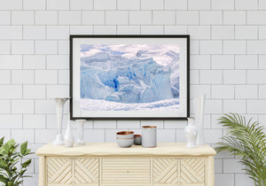 Vertical ice grooves and blue crevices rising behind a rippled snow foreground.