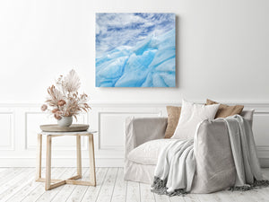 Sculpted iceberg folds and openings contrast with a softly streaked sky.